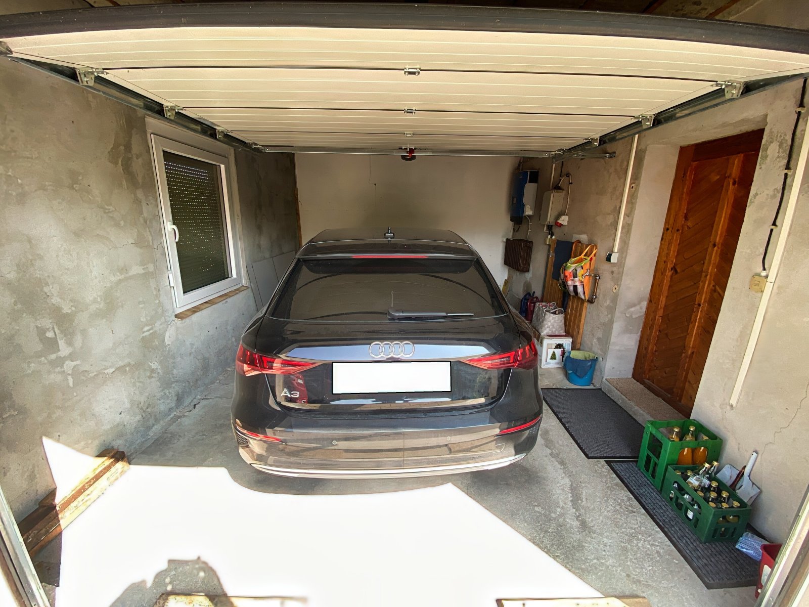 Garage mit elektrischem Tor und Zugang zum Haus