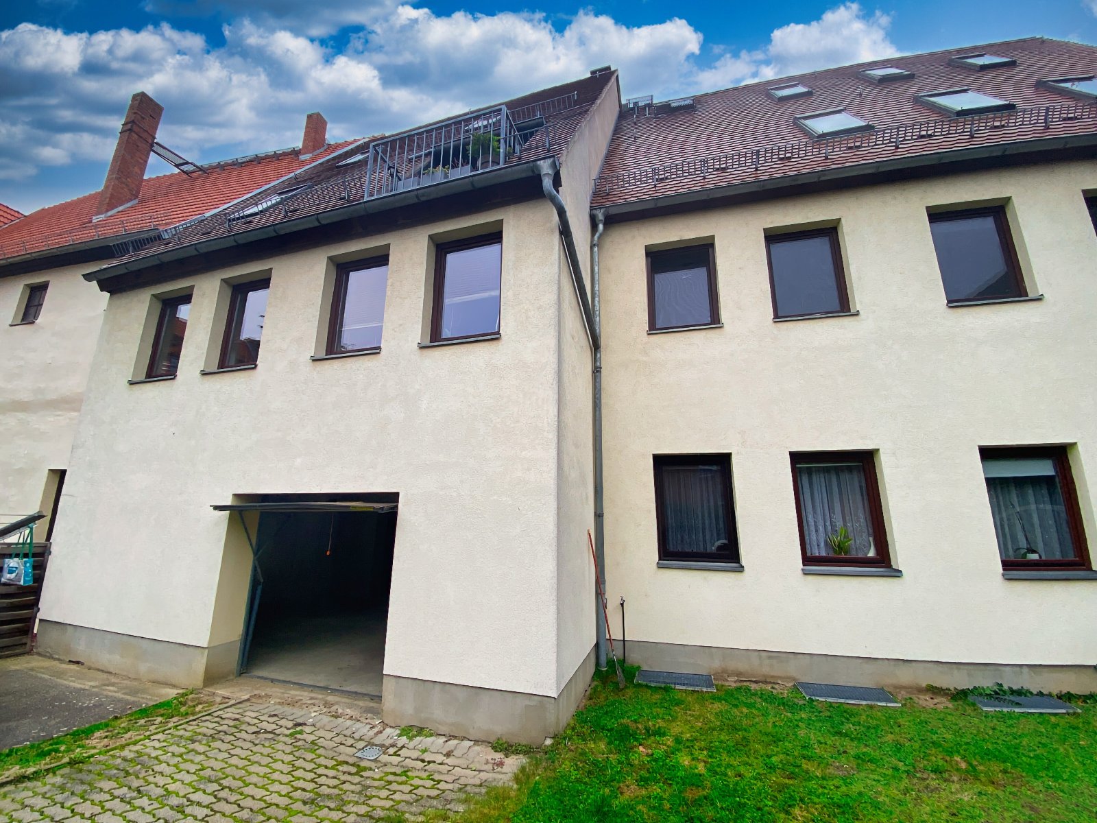 Rückseite Mehrfamilienhaus mit Garagenzugang